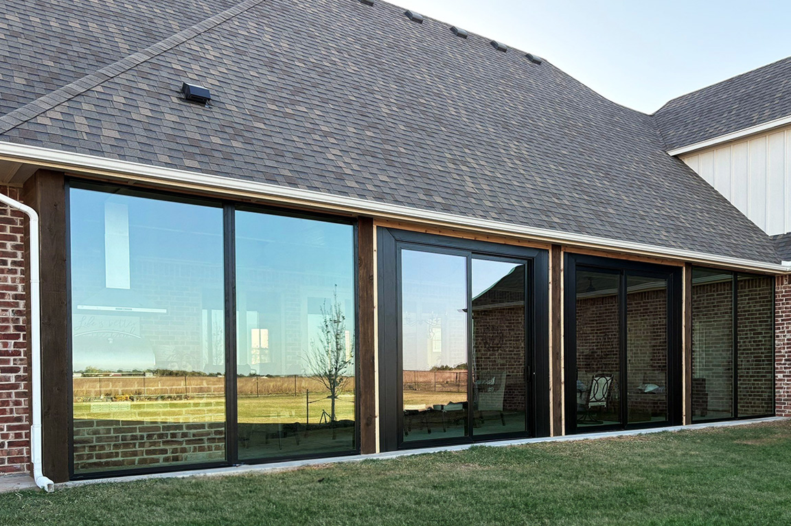 After image of patio space enclosed by black windows and doors. 