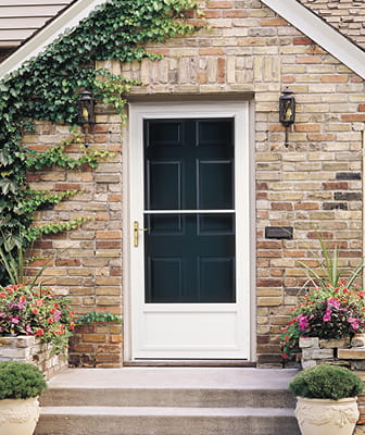 a white storm door on a brick home