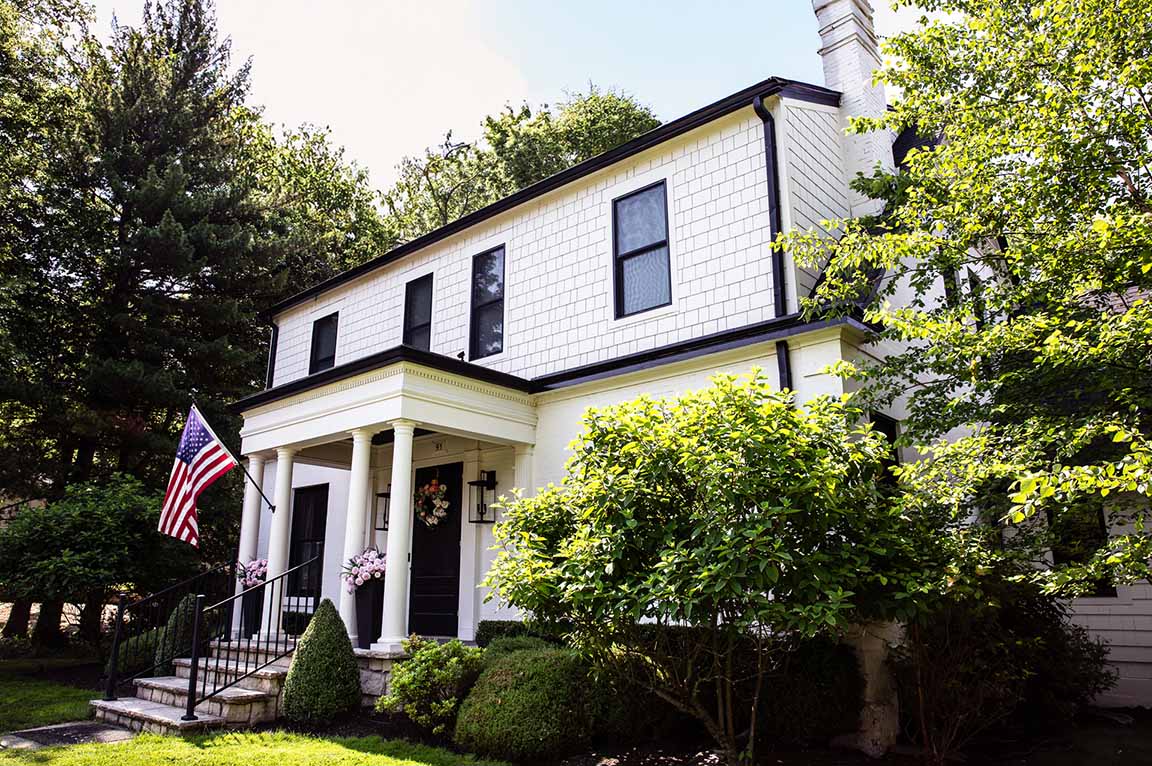 Columbus Worthington home with white siding, black trim, and a front porch with columns.