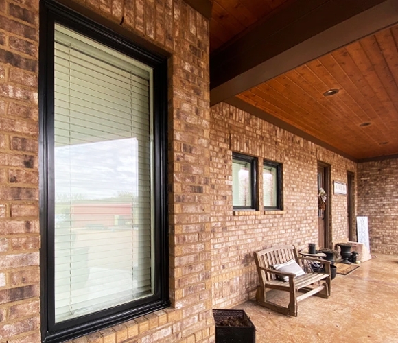 Patio of Arlington home showcasing newly installed black framed window. 