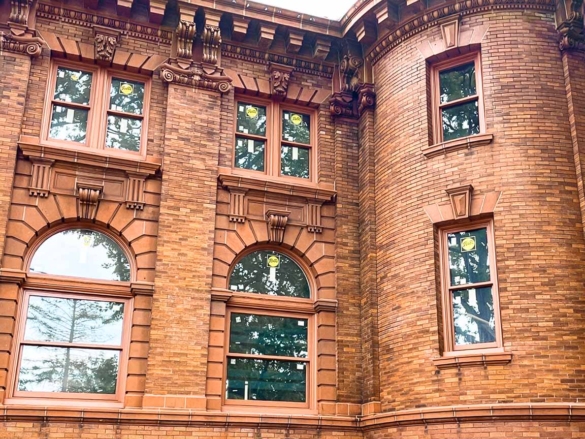 Brick facade of historic Reis Hall with tall arched windows.