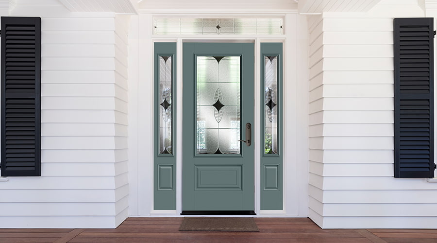A sage green front door with decorative glass and a decorative transom overhead