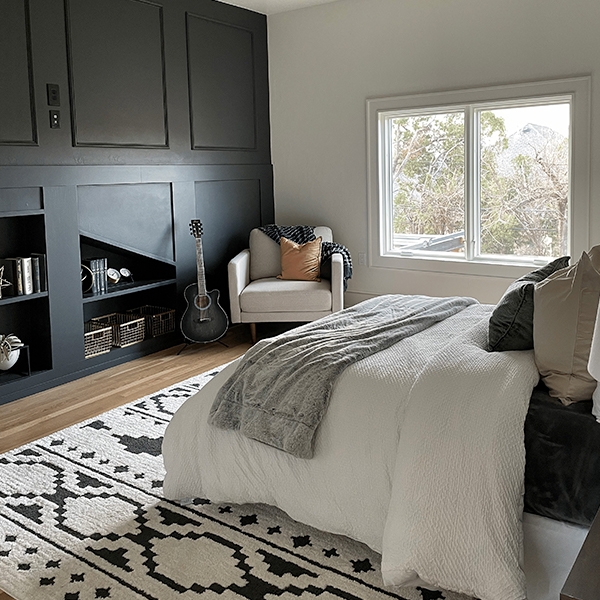 Upgraded master bedroom with a black accent wall and white sliding window behind the bed