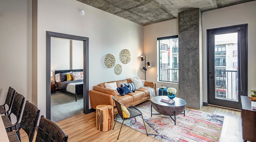 The interior of a multi-family apartment building with an orange leather couch and southwestern decor.
