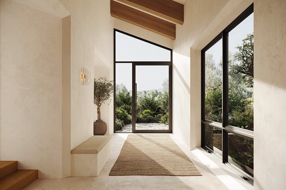 A modern beige walkway uses floor-to-ceiling aluminum fixed windows along the side which then leads to a pivot door with a triangle transom overhead.2