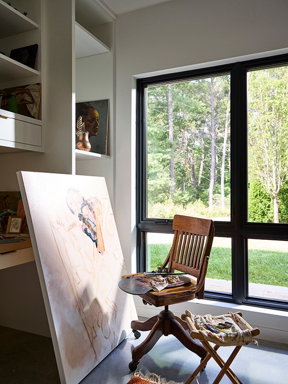 Artist studios features large black windows in mid-century modern home.