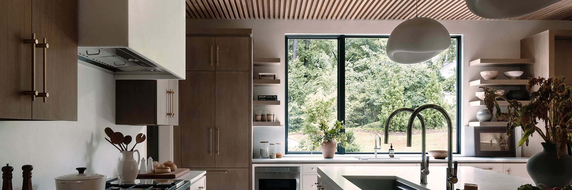 Modern kitchen with wood accents, large window, and natural light