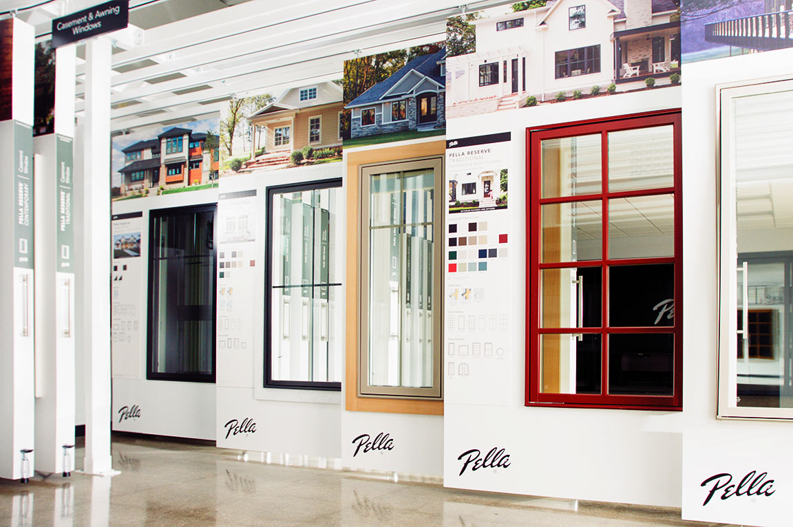 A window display in a showroom featuring various window styles and colors from Pella.