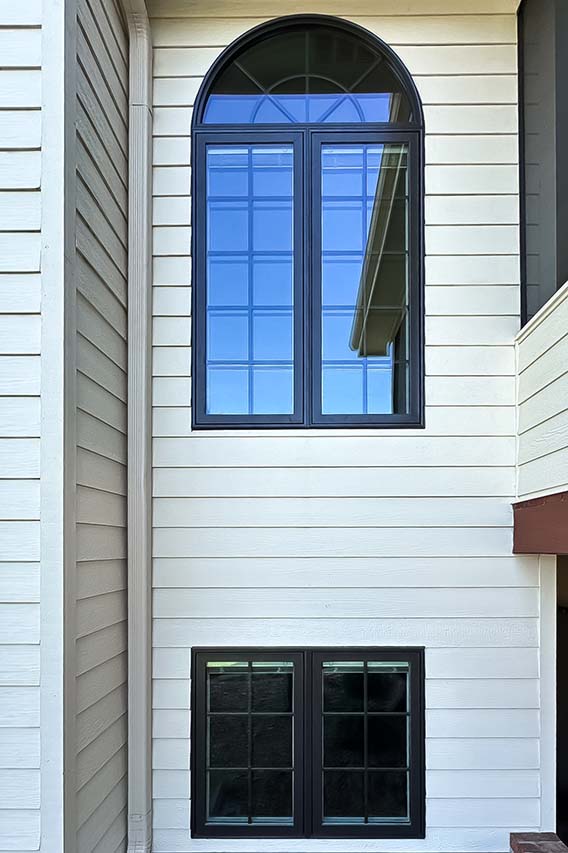 Large black arched window on home exterior.