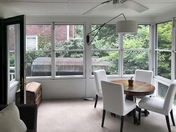 Interior view of a Cincinnati historic home sunroom with outdated windows.