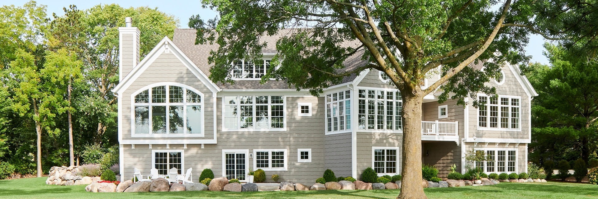 Backside of home with lots of white windows.