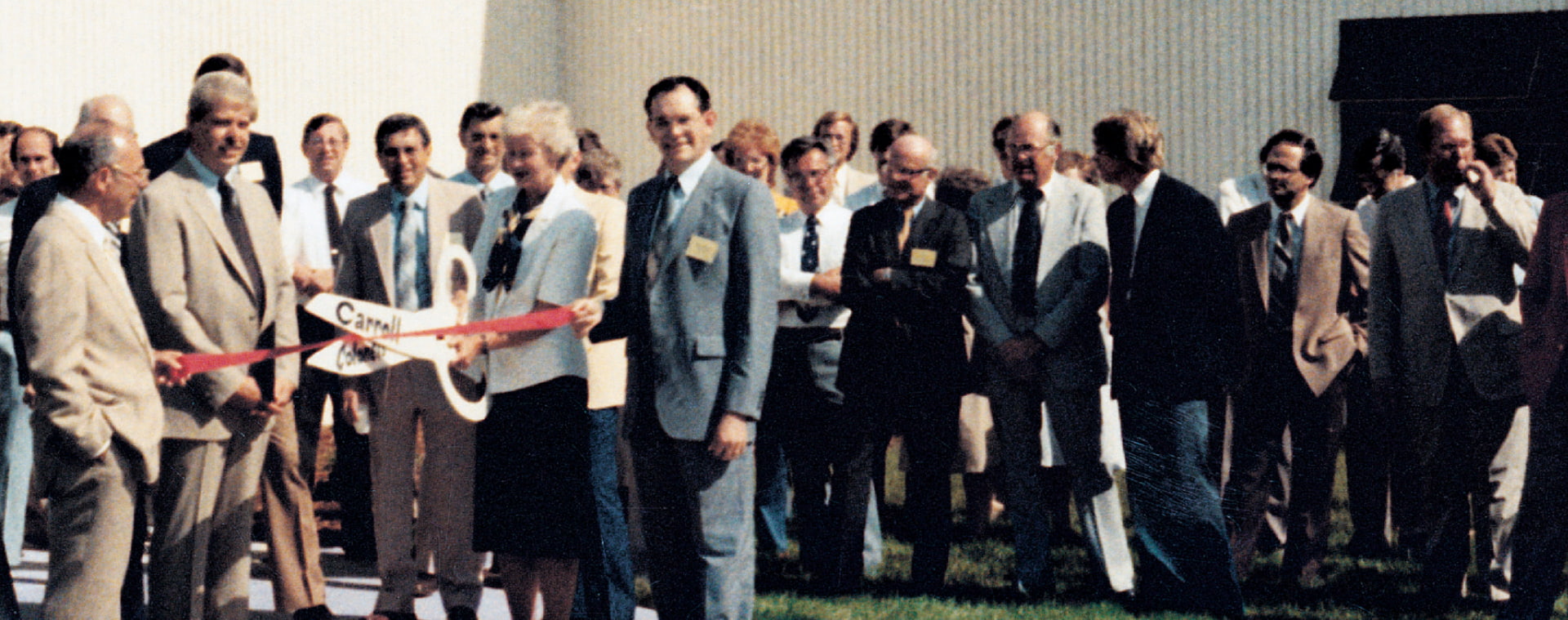 A historical photograph of the Pella leadership cutting a ribbon, opening the Carroll, Iowa Operations Center.