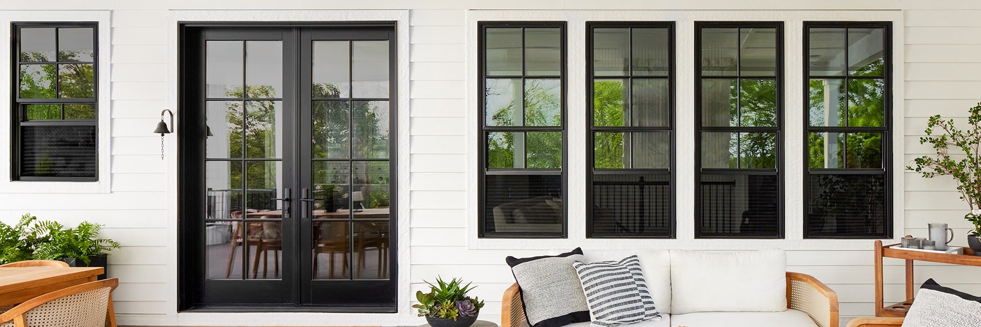 Outside patio featuring black windows and french doors with a traditional grille pattern.
