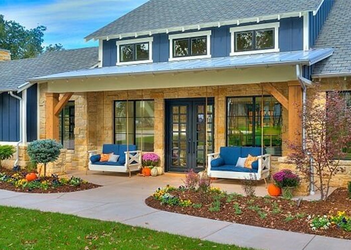 Black farmhouse windows and hinged door home entryway with blue cushions on the patio furniture