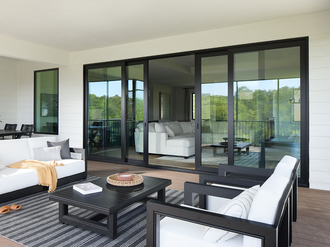outdoor furniture sits on a patio in front of a large black sliding patio door.