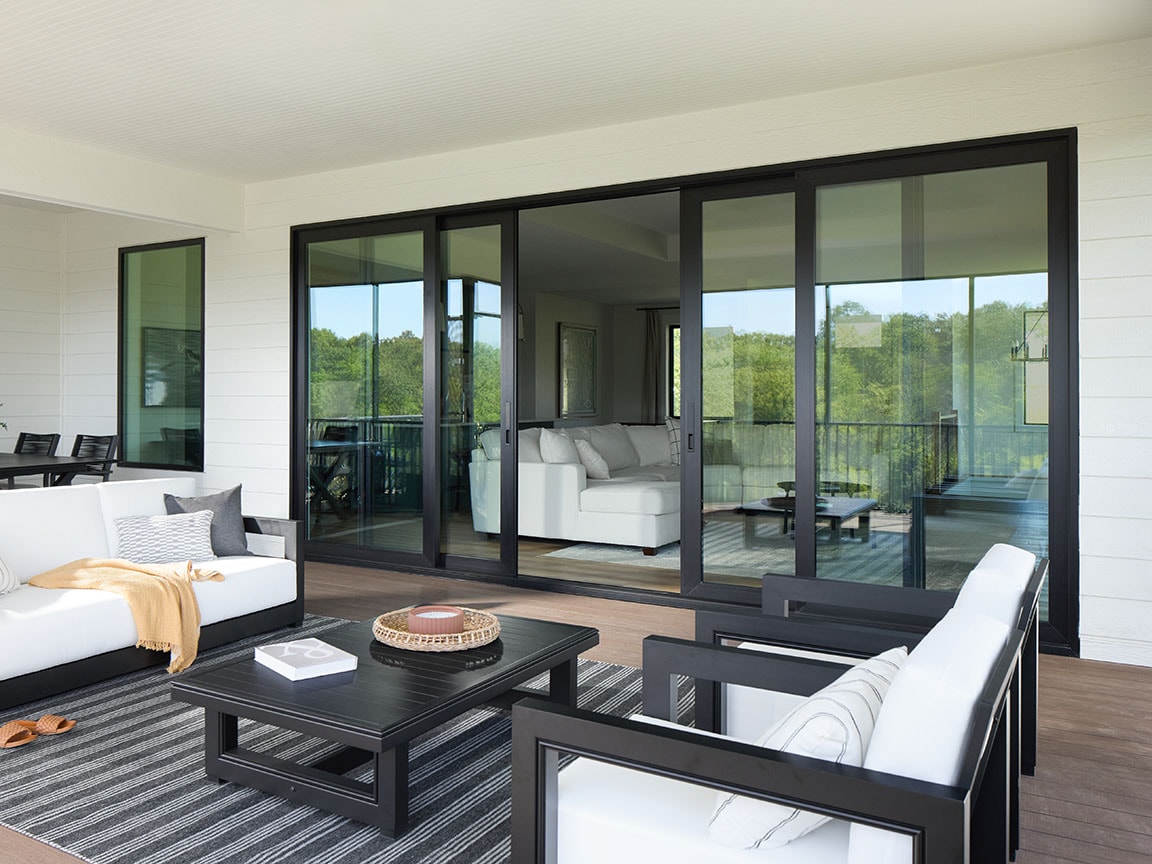 outdoor furniture sits on a patio in front of a large black sliding patio door.