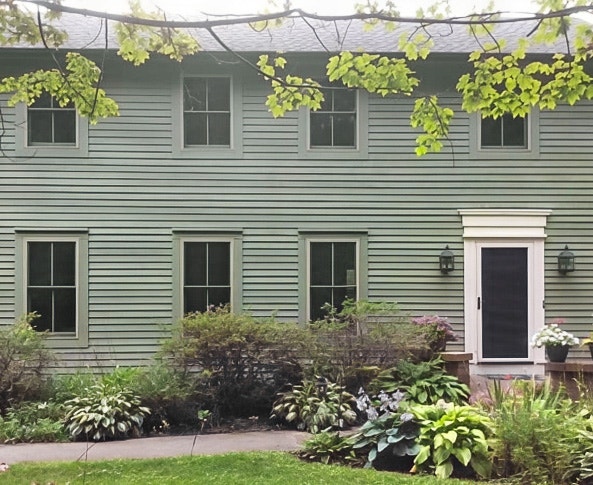 Curbside view of colonial style home with newly installed Pella wood double-hung windows.