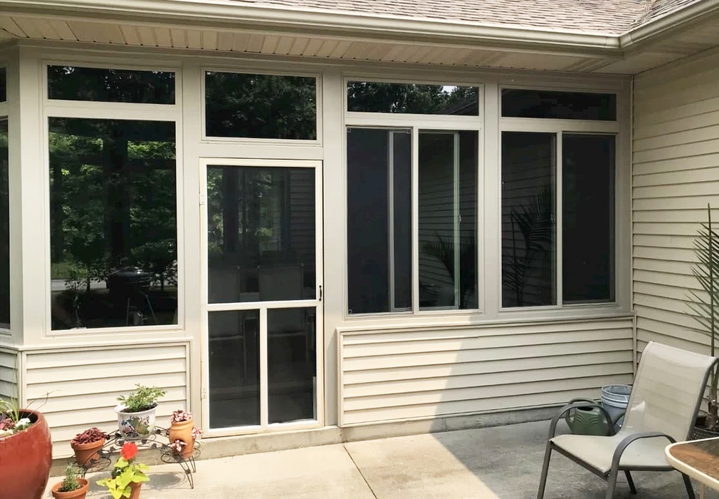 Image of a Hoagland sunroom with newly installed tan Pella 250 Series vinyl windows. 