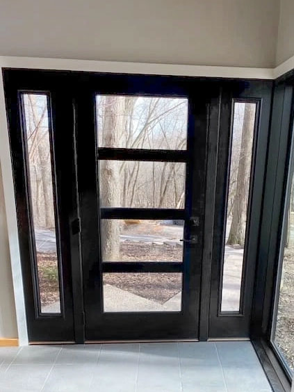 Interior photo of a new black front door in a Minnetonka home.