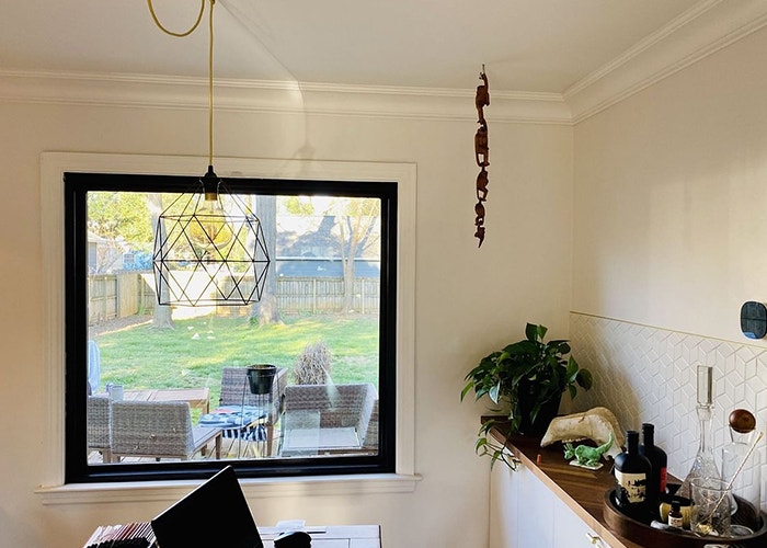 a new large fixed window brings the outdoor patio view into the home office