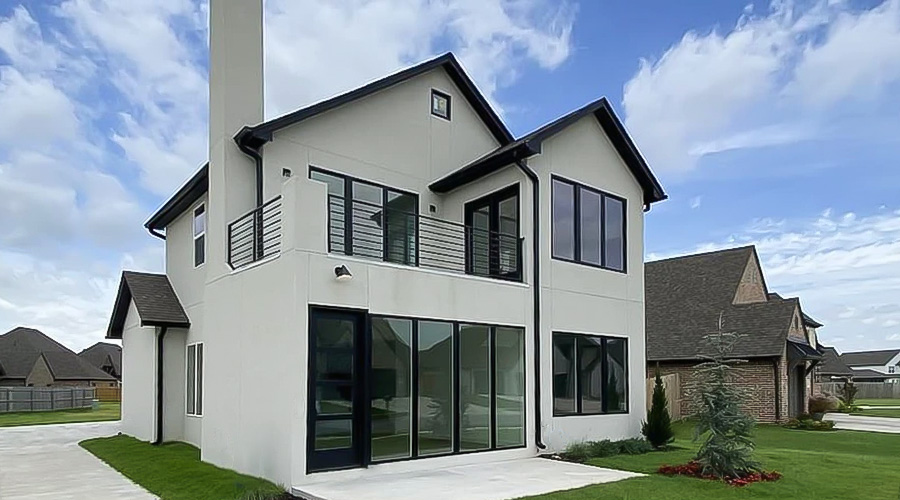 A newly constructed white home with black windows and doors in Oklahoma