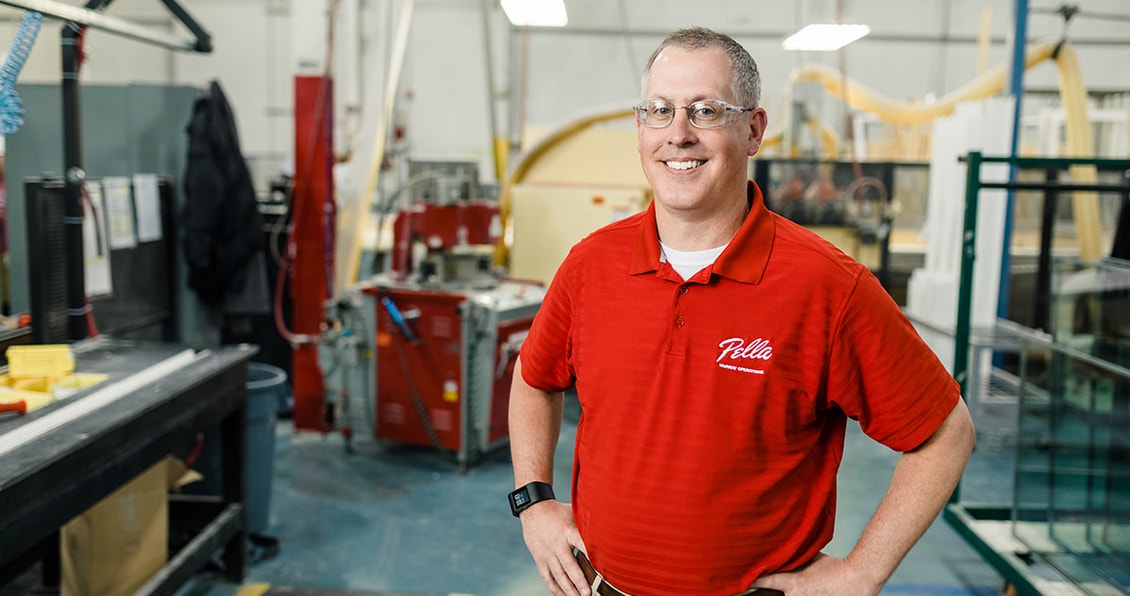 pella employee wearing a red shirt standing in the factory
