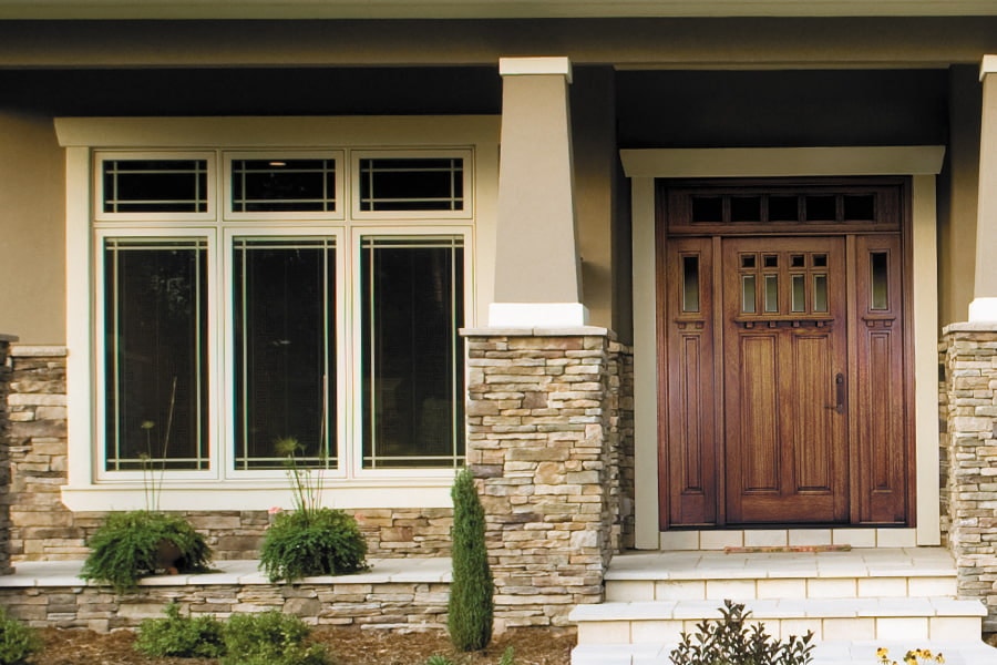 six windows with prairie grilles aside a wood front entry door