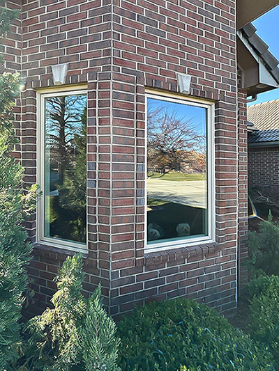 Two fixed exterior almond windows on a brick corner home in Wichita, KS.
