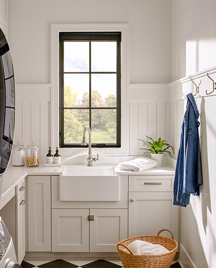 Laundry room picture window with traditional grilles overlooking trees in the distance. 
