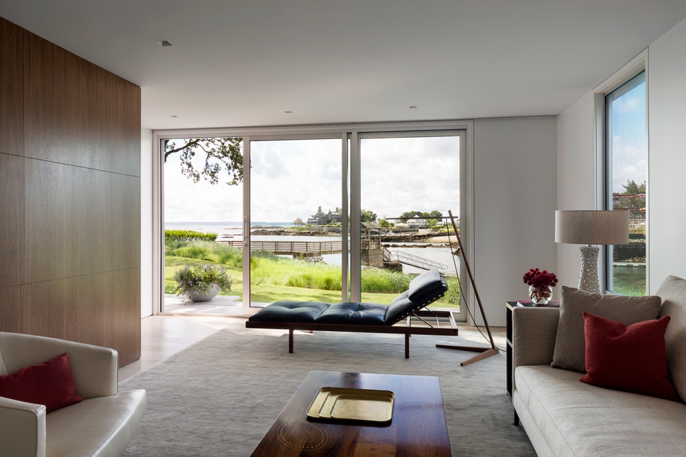 Minimalist designed living room with large sliding patio door overlooks lakeside view