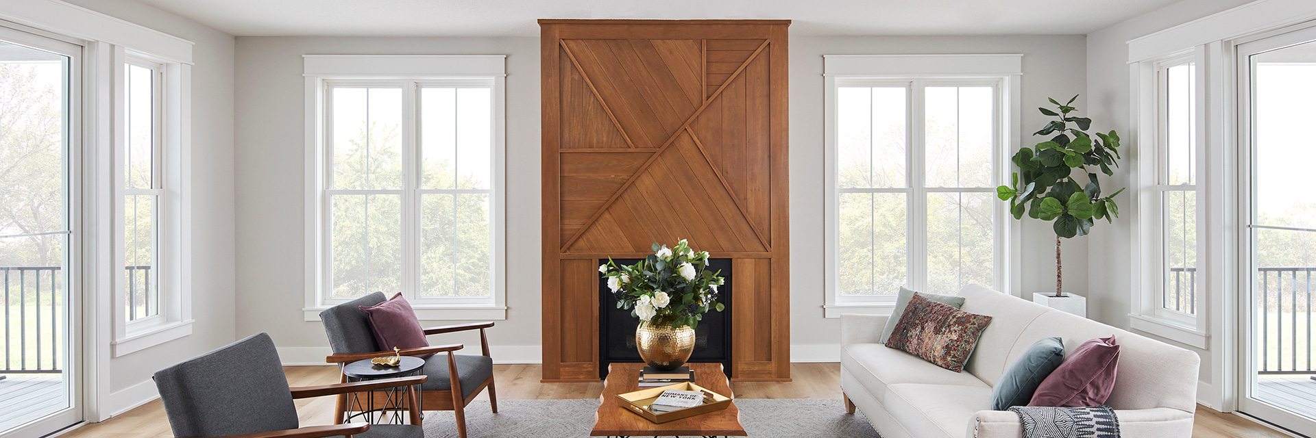 Large living room with white windows and wooden fireplace. 