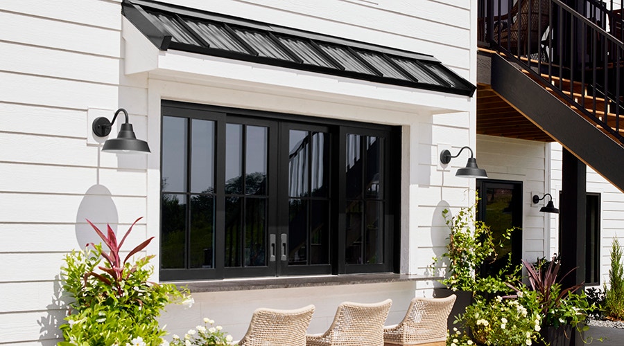 a row of black windows on a white home exterior.