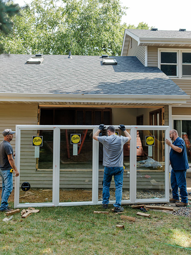 Team installing a multi-panel Pella patio door on a residential home.