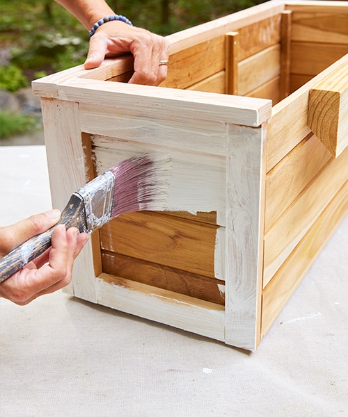 Applying a primer base coat of paint to a wood window box.