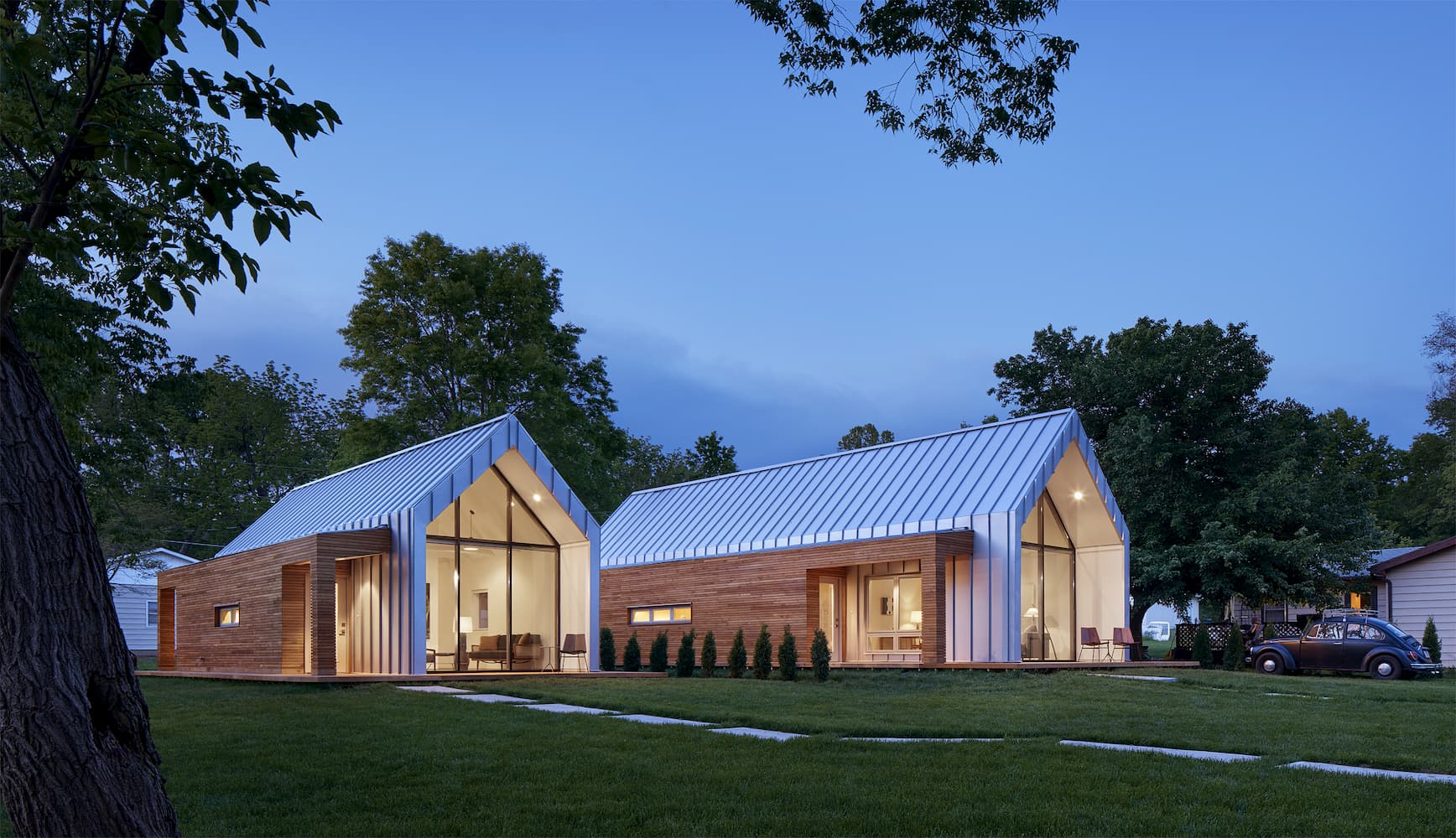 Fiberglass Picture Windows Maximize Glass In Modern Design Modern white home at dusk all lit up through floor-to-ceiling fixed windows