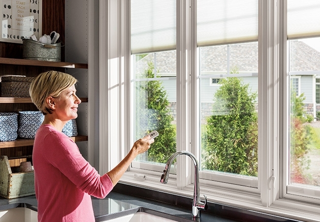 Woman using smart blinds remote.