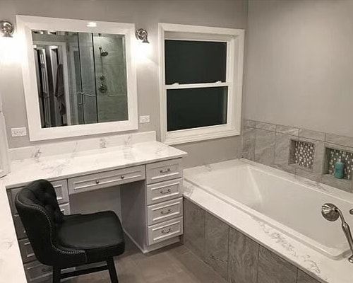 A remodeled bathroom with a soaker tub, vanity, and a white vinyl double-hung window.
