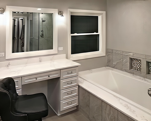 A remodeled bathroom with a soaker tub, vanity, and a white vinyl double-hung window.