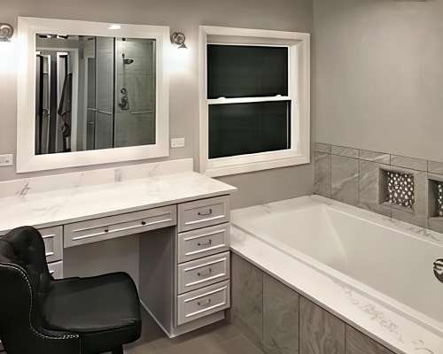 A remodeled bathroom with a soaker tub, vanity, and a white vinyl double-hung window.