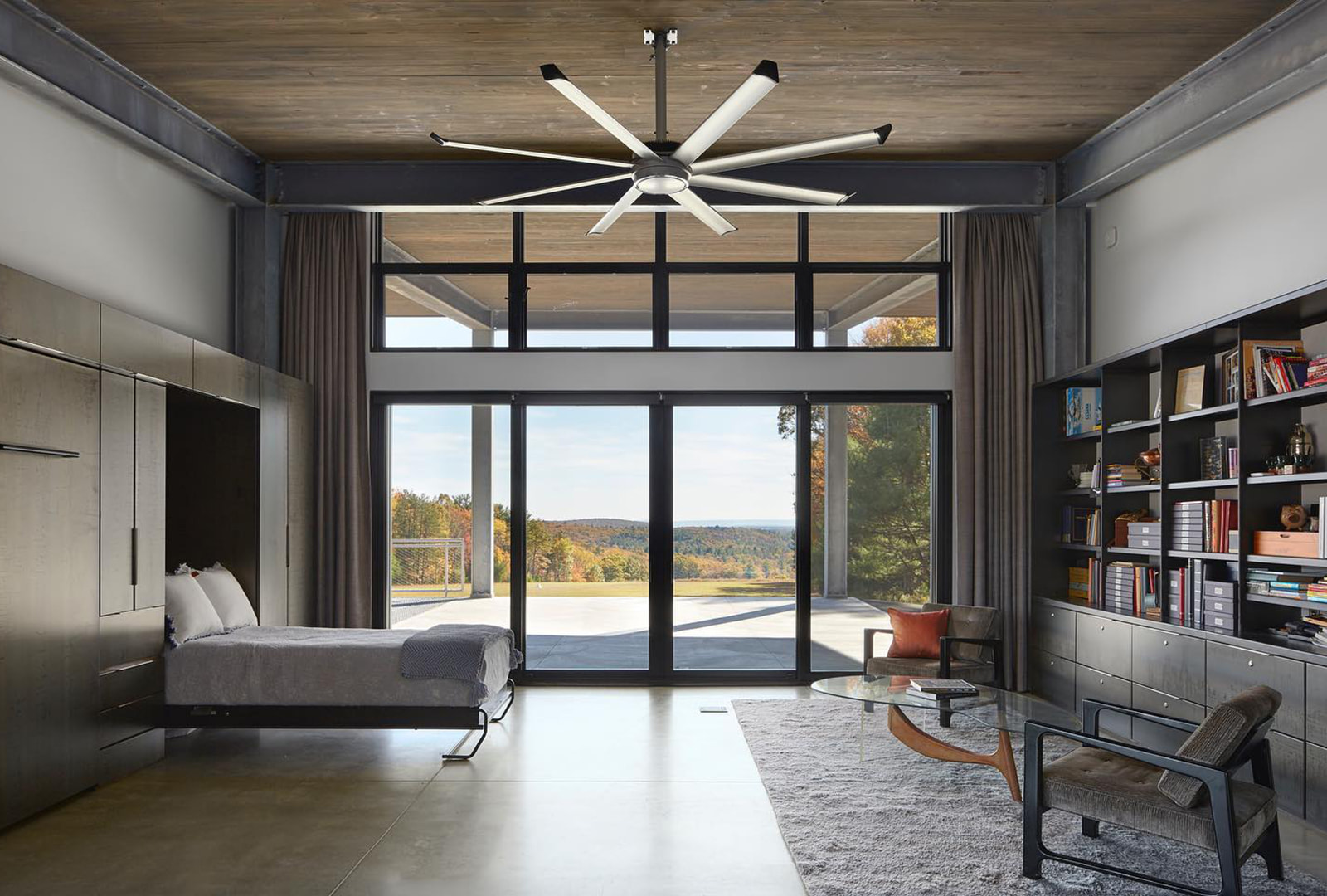 Modern contemporary bedroom has a wall with black sliding patio door and many black picture windows.