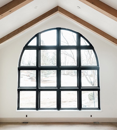 Large custom arched black window in remodeled home