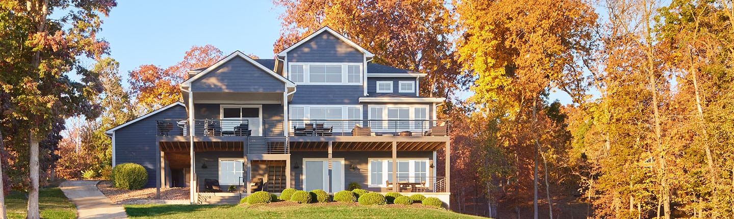 a contemporary living room features a four-panel black wood sliding patio door opening to a luxurious back deck