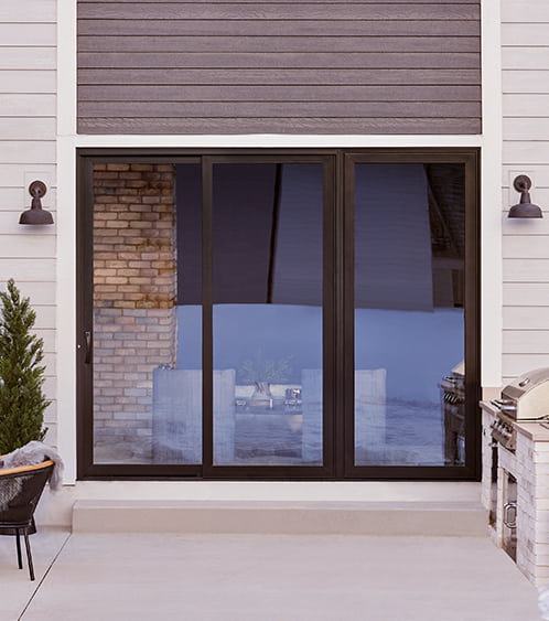 viewed from the exterior of a home, a rich brown fiberglass patio door