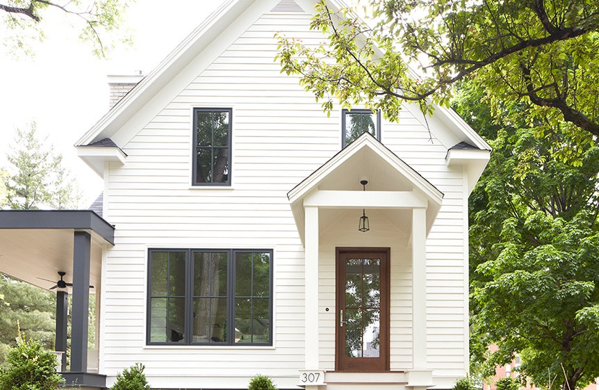 Black windows and wood entry door with cross grille pattern on modern farmhouse