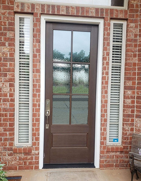 A new 3/4 light front entry door reflecting the street off the obscure glass