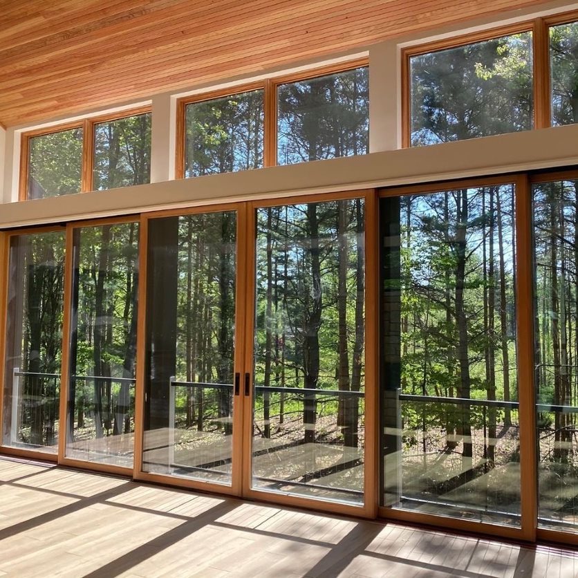 French sliding doors made of wood display expansive glass and overlook the backyard deck.