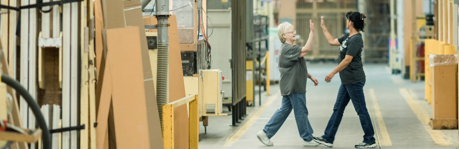 Pella Employees High-five in Factory