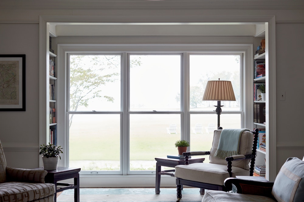 Three floor-to-ceiling double-hung windows flanked by bookcases on either side in living room