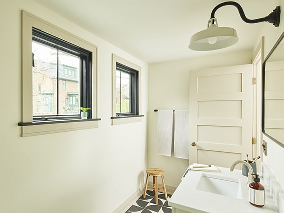 two square awning windows on a cream-colored wall in a bathroom