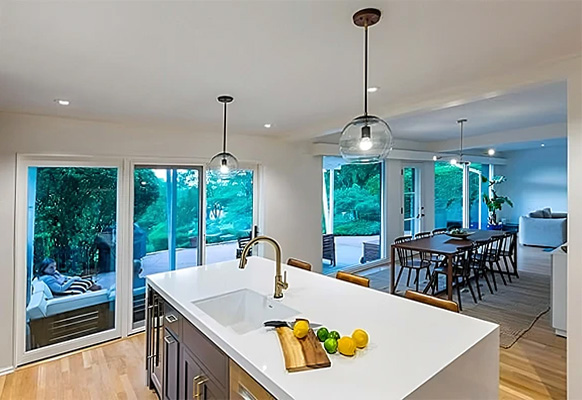 A combination of patio doors & windows extend along wall of open concept kitchen & dining room
